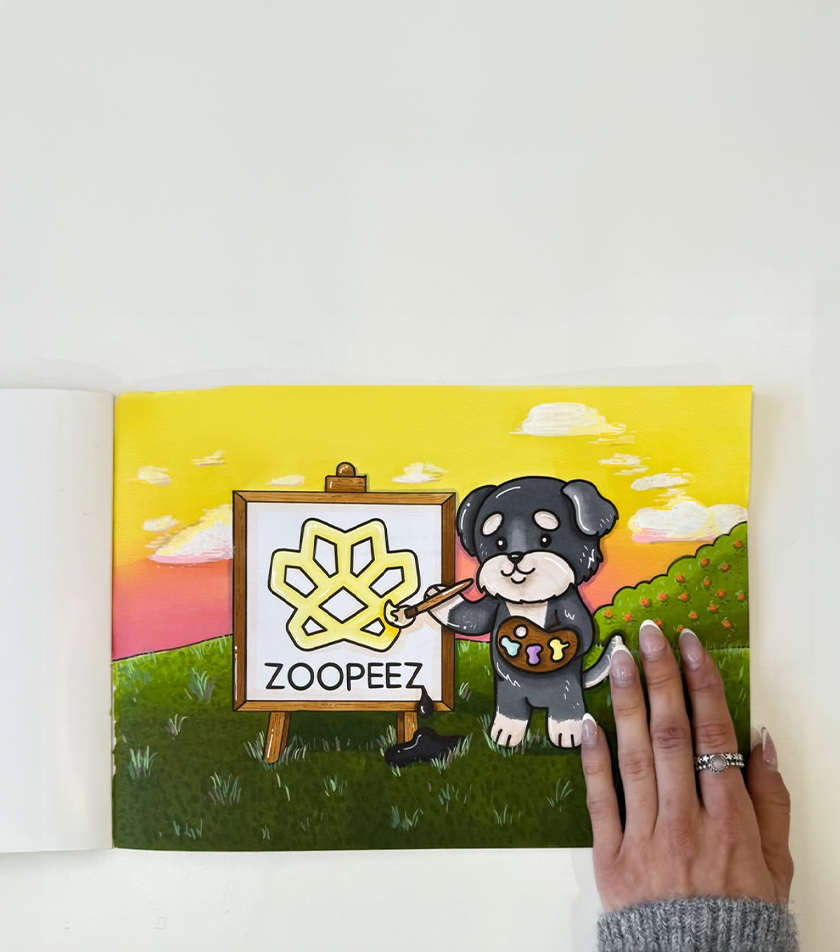 Canvas print with a cartoon dog painting the Zooppee logo, held by a hand.