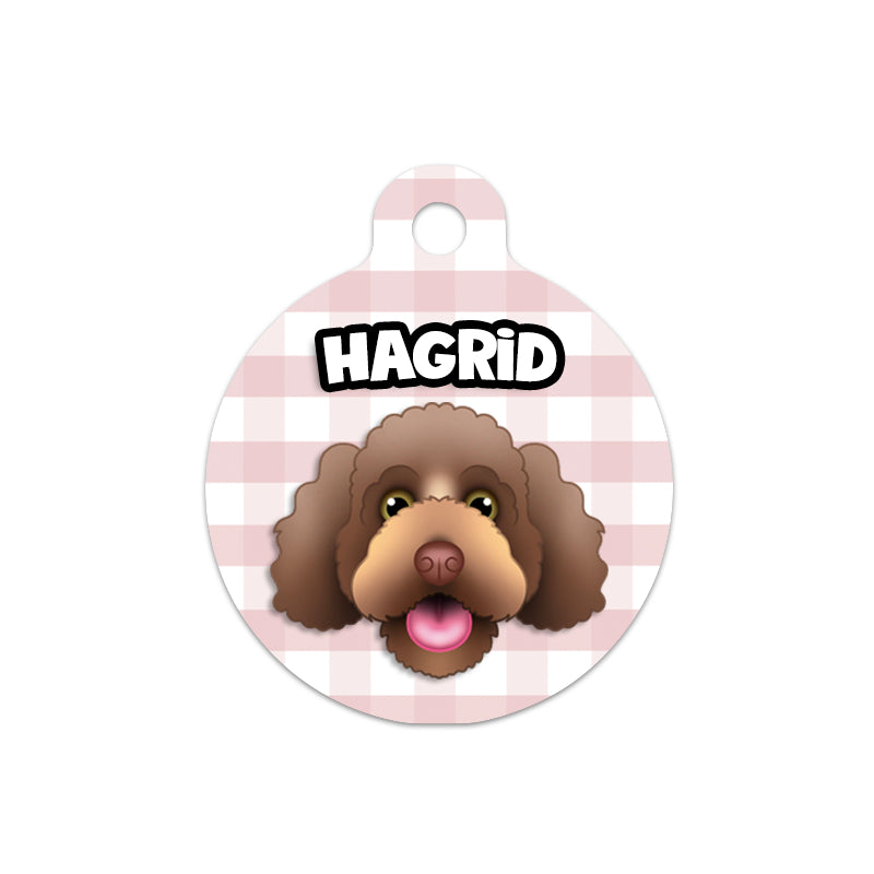 A custom dog portrait tag with a hand-drawn illustration of a brown dog's face on a pink checkered background. The name 'Hagrid' is printed at the top.